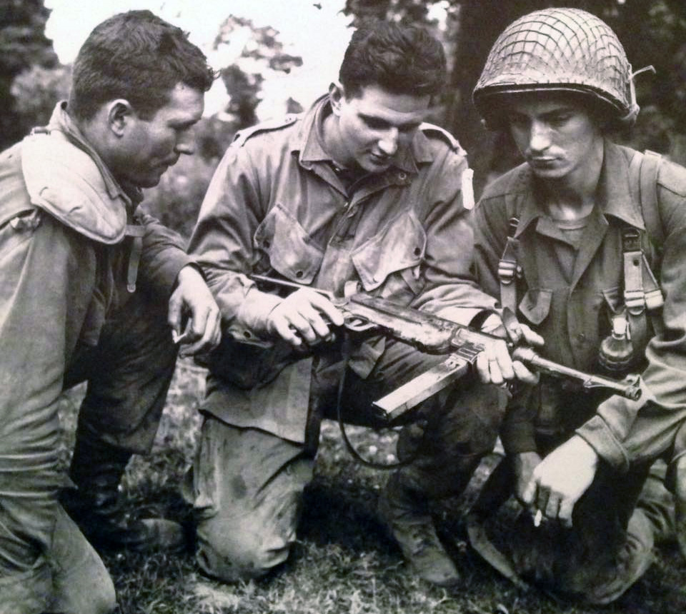 Three members of the 101st. Airborne Division inspect a capture MP40 machine pistol
